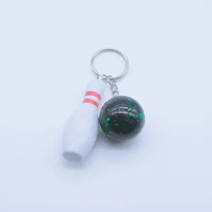 Detailed view of mini bowling pin and ball keychain pendant with silver metal ring