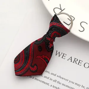 Dettaglio macro di un portachiavi a mini cravatta rossa e nera con motivo paisley