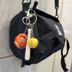 Sports-themed keychain set with mini wooden bat, orange glove, and yellow baseball charm.