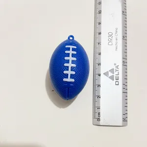 Macro-detail van een blauwe mini-American football sleutelhanger naast een metalen liniaal
