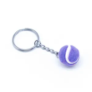 Paarse mini tennisbal sleutelhanger met zilveren metalen ring op witte achtergrond