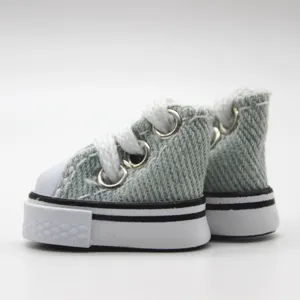 Macro view of tiny 3.5cm light blue denim doll sneakers with white laces