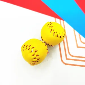 Macro detail of two mini yellow softballs with red stitching for keychain accessories