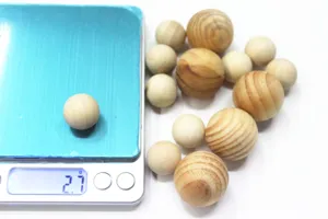 Detailopname van kleine natuurlijke houten kralen op een digitale weegschaal met 2,7 g gewicht