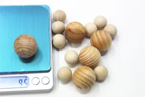 Macro-detail van een natuurlijke houten bal gewogen op een weegschaal van 9,5 g
