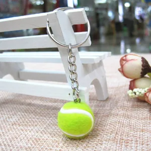 Gedetailleerd overzicht van mini neon groene tennisbal sleutelhanger van 2 cm met ring