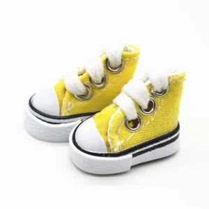 Detailed macro shot of yellow 3.5cm miniature canvas shoes for dolls