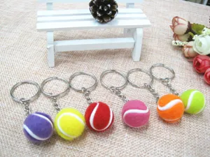 Detailweergave van zes kleurrijke 2cm mini tennisbal sleutelhangers met metalen ringen.