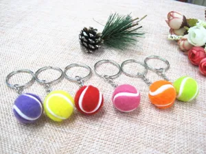 Detailopname van kleurrijke 2cm mini tennisbal sleutelhangers met metalen ringen