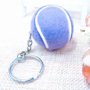 Primer plano detallado de un llavero de pelota de tenis violeta con textura suave y aro