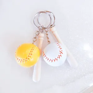Detailopname van mini-honkbal sleutelhangers met houten knuppels en rode stiksels.