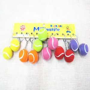 Colección de mini llaveros de pelotas de tenis de colores en un cartón amarillo