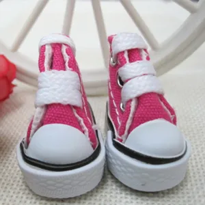 Detail view of 3.5cm mini pink canvas doll shoes with white laces and rubber soles.