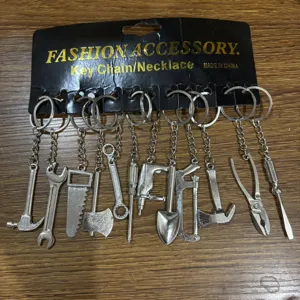 Detailed view of mini tool metal keychains set including hammer and wrench on black display card