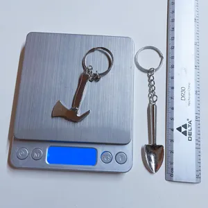 Detailed view measuring weight and size of stainless steel mini axe and shovel keychains.