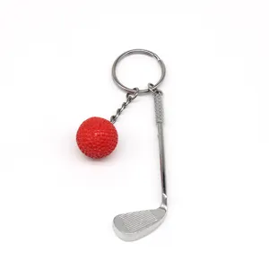 Gedetailleerd overzicht van golfsleutelhanger met rode bal en zilveren golfclub.