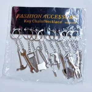 Detailed view of miniature metal tool keychain set including hammer, saw and wrench.