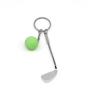 Gedetailleerde weergave van een metalen golfclub en groene bal sleutelhanger
