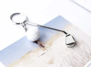 Detailopname van een zilveren golfclub sleutelhanger met een witte getextureerde bal