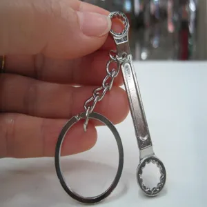 Close-up view showing the details of a mini silver metal wrench keychain tool