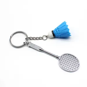 Detailopname van een creatieve mini zilveren badmintonracket en blauwe shuttle sleutelhanger
