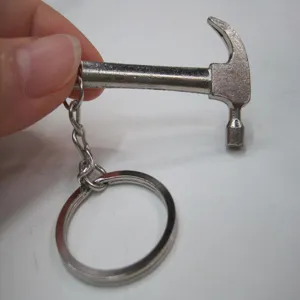 Close-up detail showing the metallic texture of a mini stainless steel hammer tool keychain