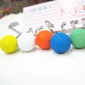 Macro-opname van kleurrijke mini-golfbal sleutelhangers in geel, wit, oranje, blauw en groen.
