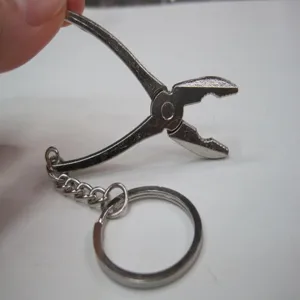 Miniature silver metal pliers keychain detail featuring a sturdy split ring connector