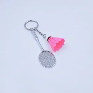 Gedetailleerd overzicht van zilveren mini-badmintonracket en roze shuttle sleutelhanger-set.