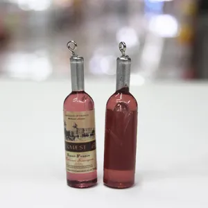 Gros plan de mini breloques bouteilles de vin rouge avec étiquettes pour porte-clés