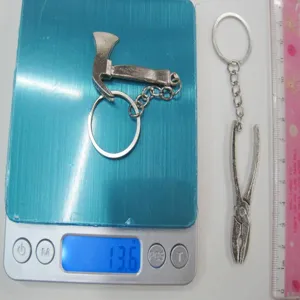 Detail view of miniature tool keychains showing weight of 13.6g on a digital scale.