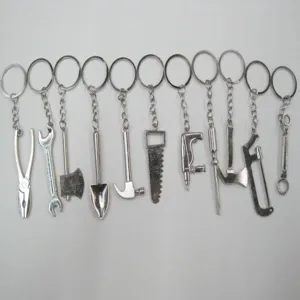 Collection of miniature stainless steel tool keychains including saws and wrenches.