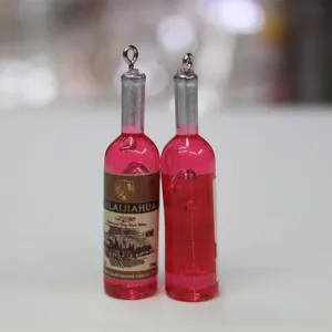 Vue détaillée de mini breloques bouteilles de vin rouge avec boucles de suspension argent