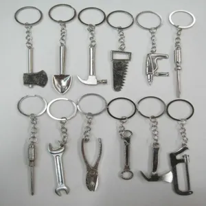 Collection of 12 miniature metal hardware tool keychains including hammer and saw