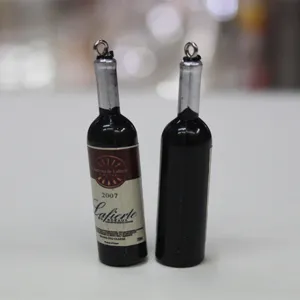 Détail de deux pendentifs miniatures en forme de bouteille de vin avec étiquettes