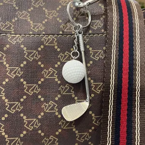 Creatieve mini golfbal en club sleutelhanger accessoire aan een designer-stijl handtas