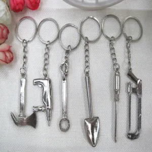 Detailed view of miniature metal tool keychains featuring axe, shovel, and saw models.