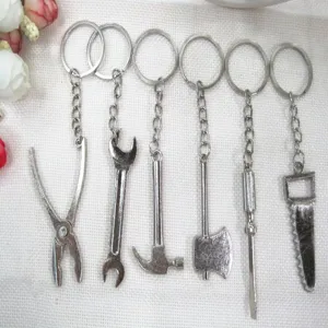 Set of six miniature silver metal tool keychains including hammer, saw and wrench