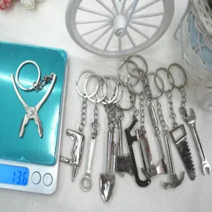 Detailed macro view of a mini silver tool keychain being weighed on a digital scale