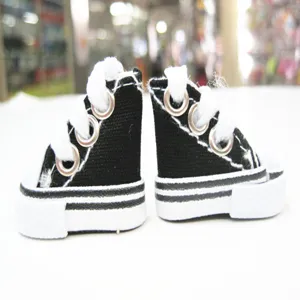 Detailed macro shot of 3.5cm miniature black canvas sneakers for dolls and keychains
