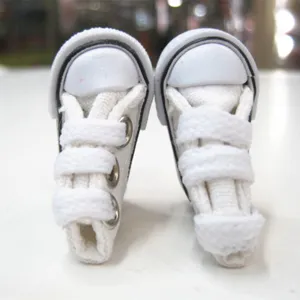 Detailed close-up view of 3.5cm miniature white canvas shoes for doll accessories.
