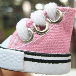 Macro view showing the fine stitching and canvas texture of a mini pink doll shoe