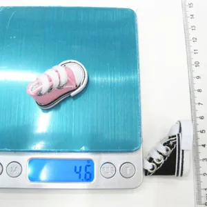 Miniature 3.5cm pink canvas doll shoe on a digital scale showing 4.6g product weight