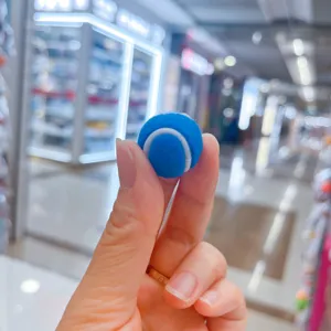 Detailansicht eines miniaturen blauen Tennisball-Schlüsselanhängers in der Hand