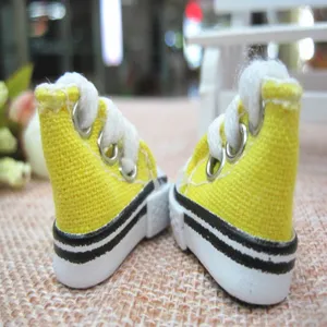 Close-up detail of 3.5cm miniature yellow canvas sneakers for dolls and keychains