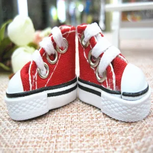 Close-up of 3.5cm miniature red canvas high-top sneakers for doll accessories.