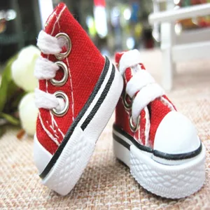 Close-up of 3.5cm red mini canvas doll shoes with white laces and striped soles