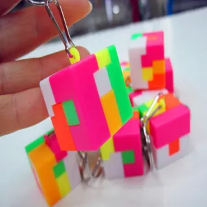 Close-up detail of a mini 2.5cm colorful puzzle cube keychain toy held in a person's hand