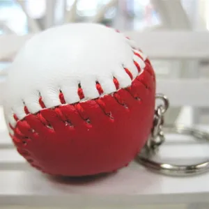 Detailopname van een rood-witte lederen honkbal sleutelhanger met zichtbare stiksels.