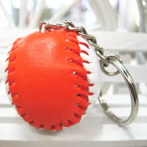 Macro-weergave van een oranje en witte honkbal sleutelhanger met rode stiksels.